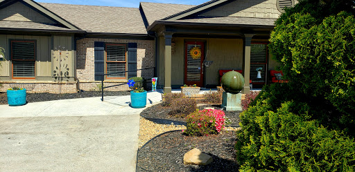 A well-maintained front yard featuring a decorative sphere and vibrant plants.