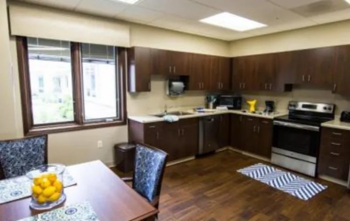 A modern kitchen interior with wooden cabinets and stainless steel appliances.