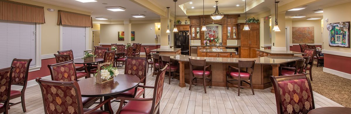A spacious and elegantly designed kitchen and dining area with wooden furniture and pendant lighting.
