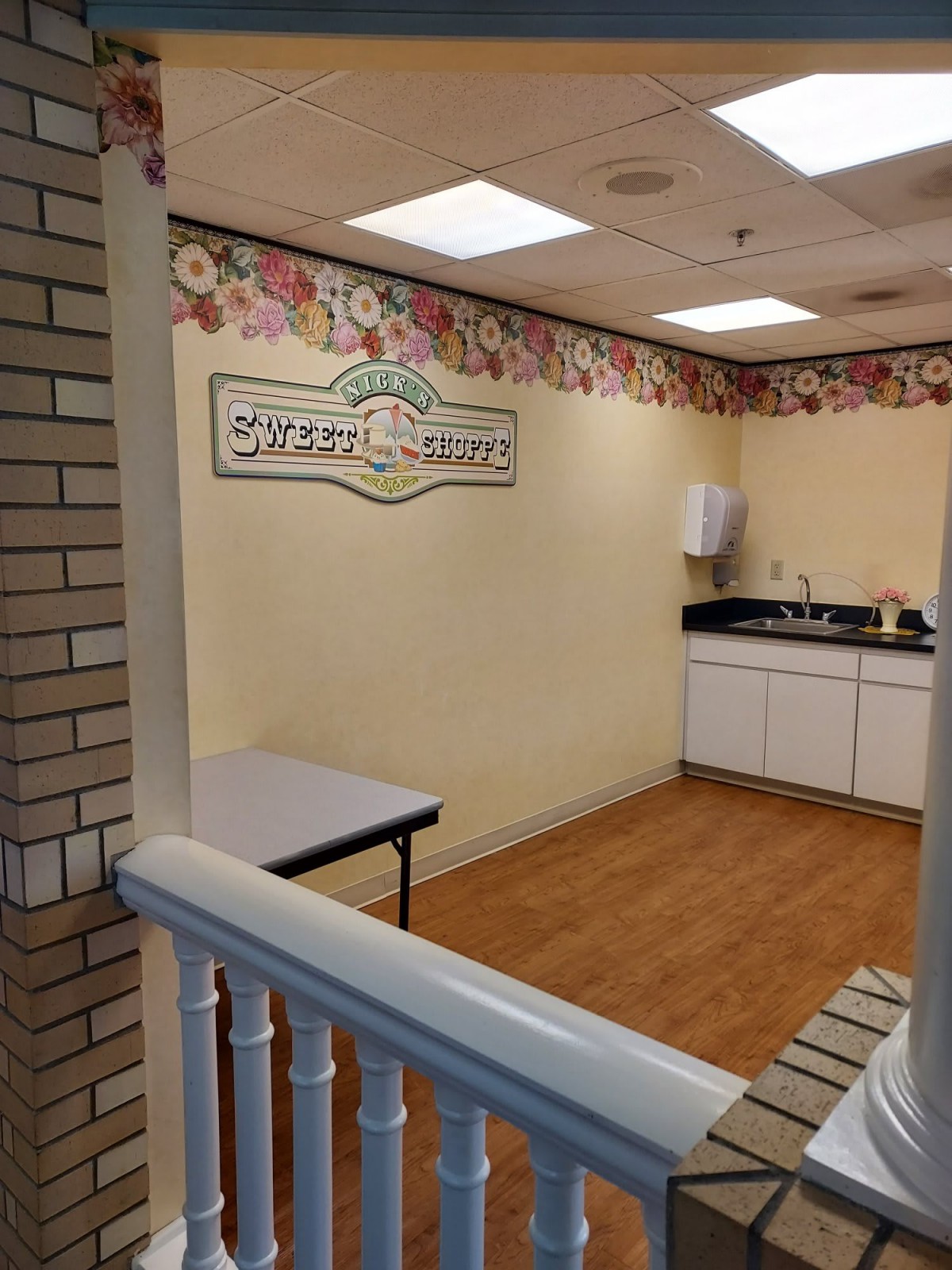 A small kitchenette with floral decor and basic amenities.