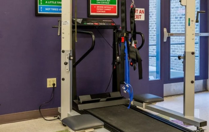 A treadmill and other gym equipment set up in an indoor fitness area.