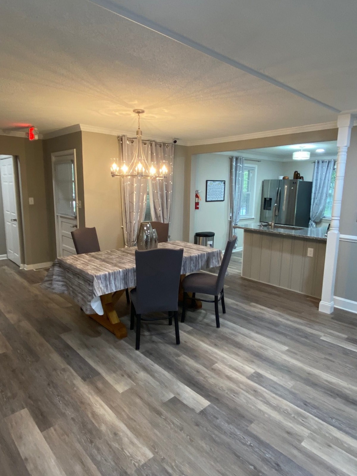 A modern dining area with a table set for six, adjacent to an open kitchen.