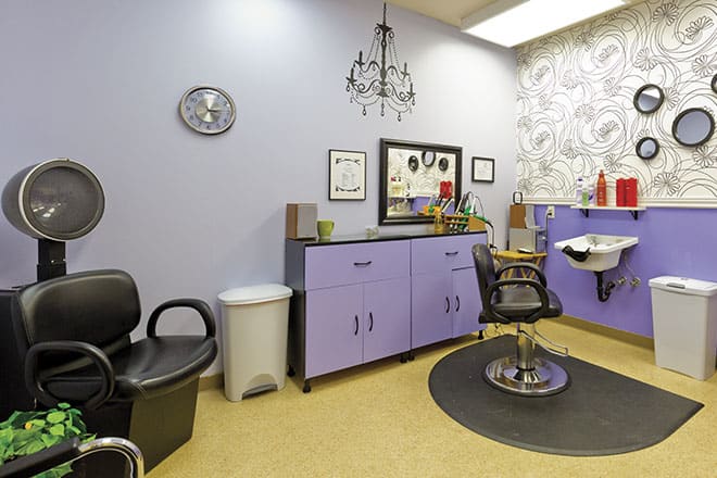 A well-decorated salon interior with a hairdressing chair and mirror.