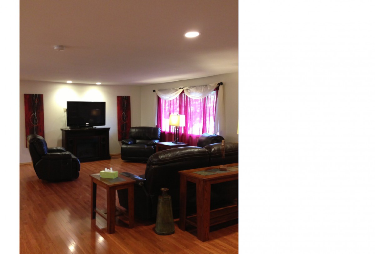 A cozy living room with leather sofas and a television.