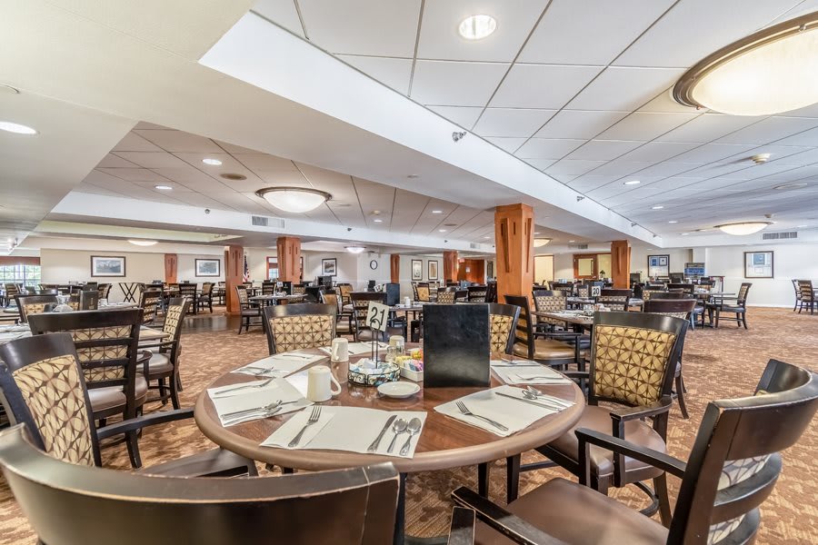 A spacious and elegantly designed restaurant dining area with neatly arranged tables and chairs.