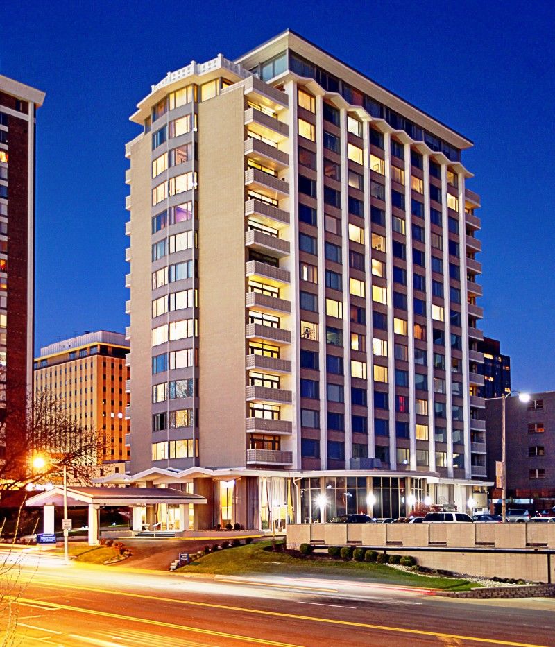 A brightly lit high-rise hotel building at night in an urban setting.