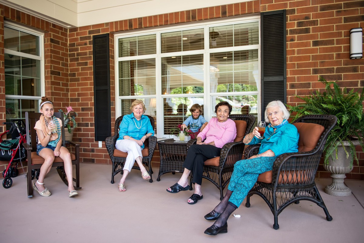 A group of seniors relaxing and chatting on a patio.