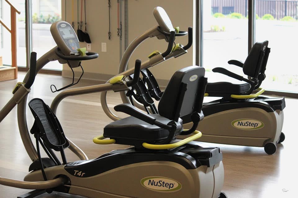 A pair of stationary bikes in a gym setting.