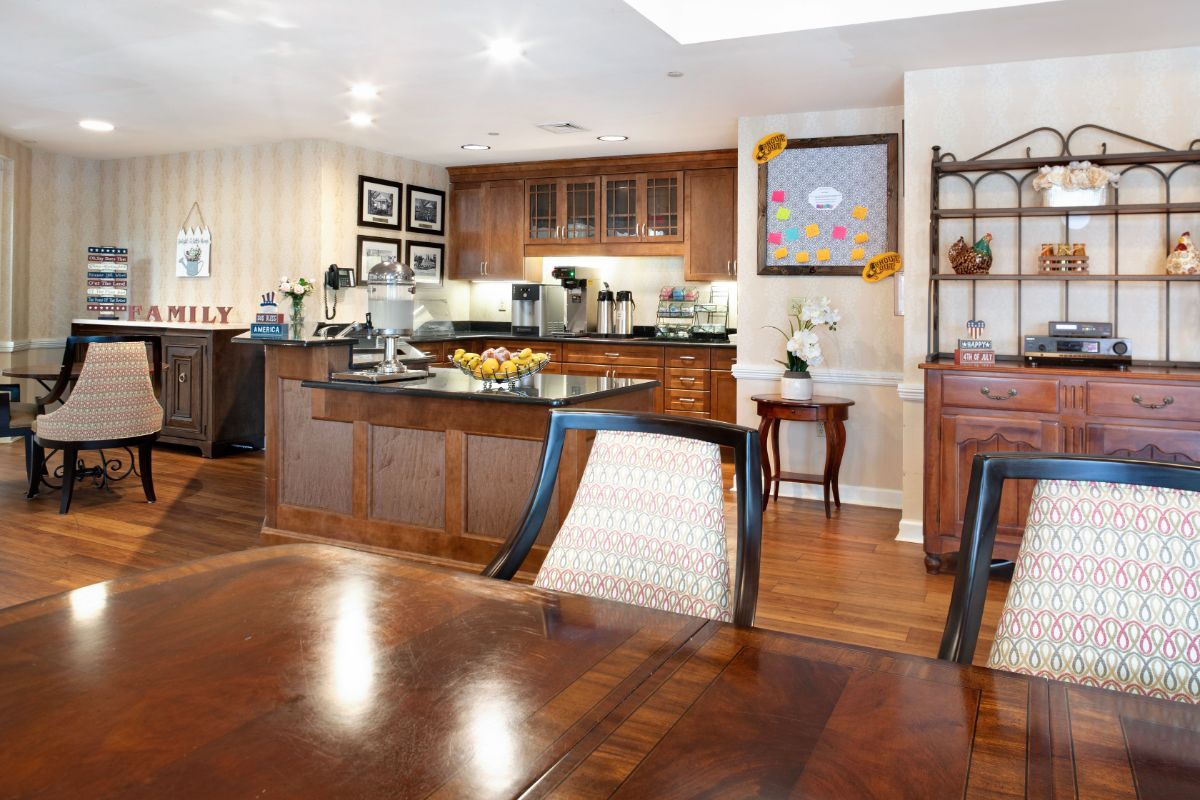 A modern kitchen with a wooden floor and breakfast bar, featuring sleek cabinetry and appliances.
