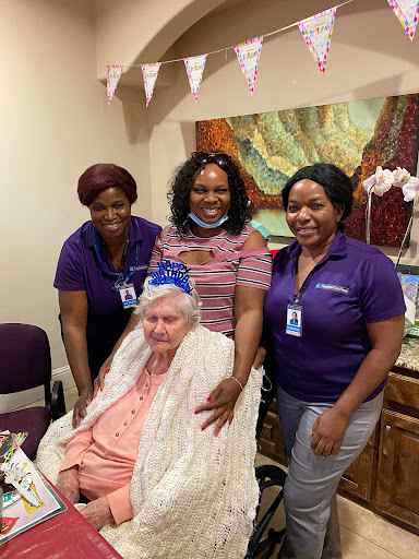A joyful moment shared among caregivers and an older adult, celebrating together.