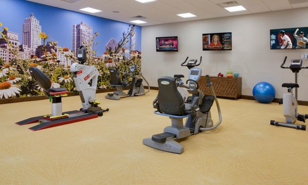 A well-lit gym space featuring various exercise machines for cardio workouts.