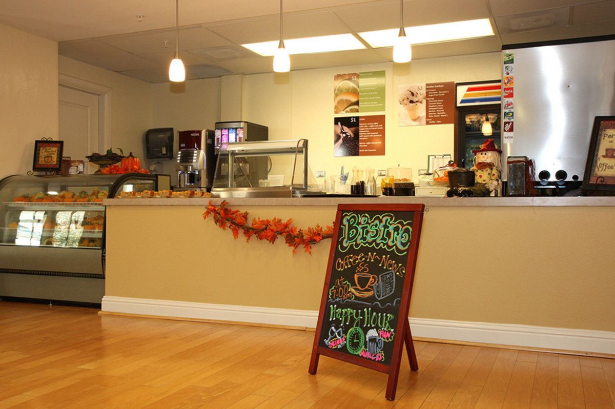 A cozy cafe interior with a signboard and festive decorations.