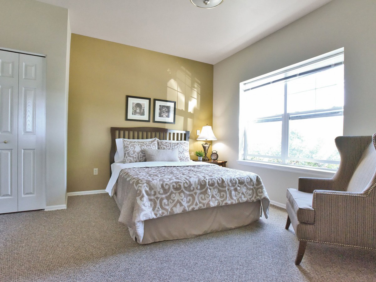 A cozy bedroom with a large window and elegant decor.