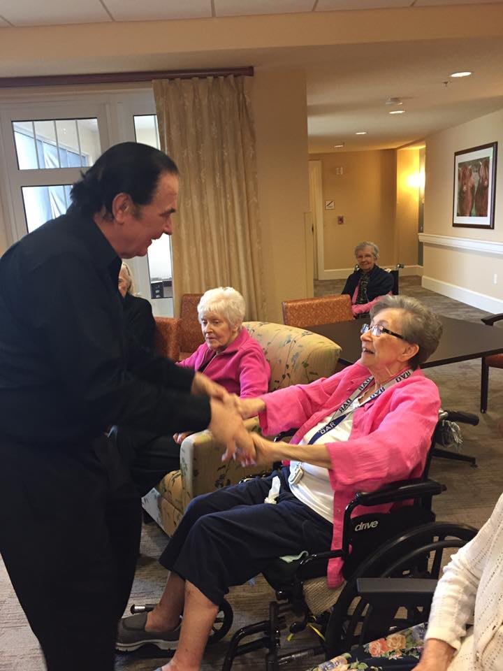 Elderly residents enjoying a friendly interaction in a nursing home setting.