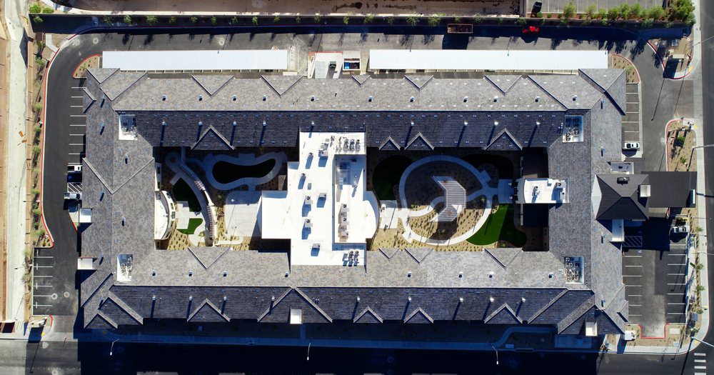 Aerial perspective of a modern building rooftop featuring unique architectural elements and outdoor spaces.