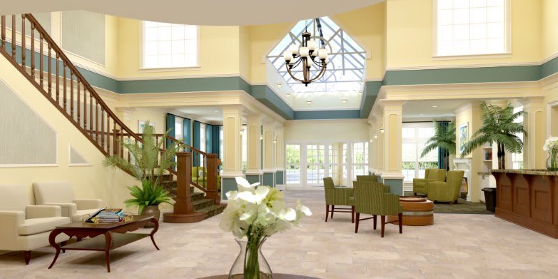 A modern and spacious lobby with elegant furniture and a central chandelier.