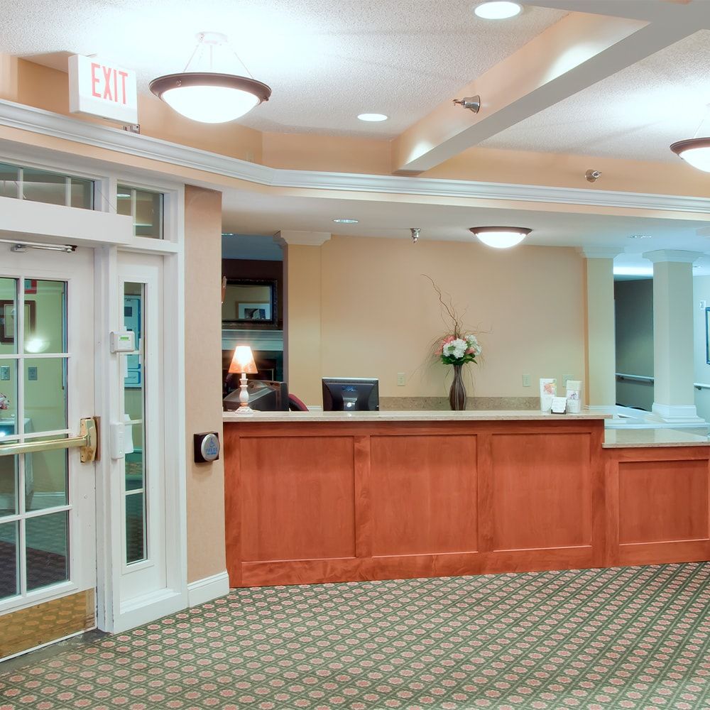 A hotel lobby featuring a reception desk with warm lighting and comfortable furnishings.