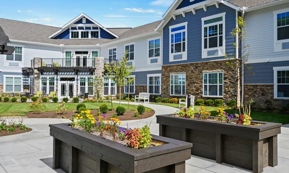 Modern residential building with landscaped garden and flower beds.