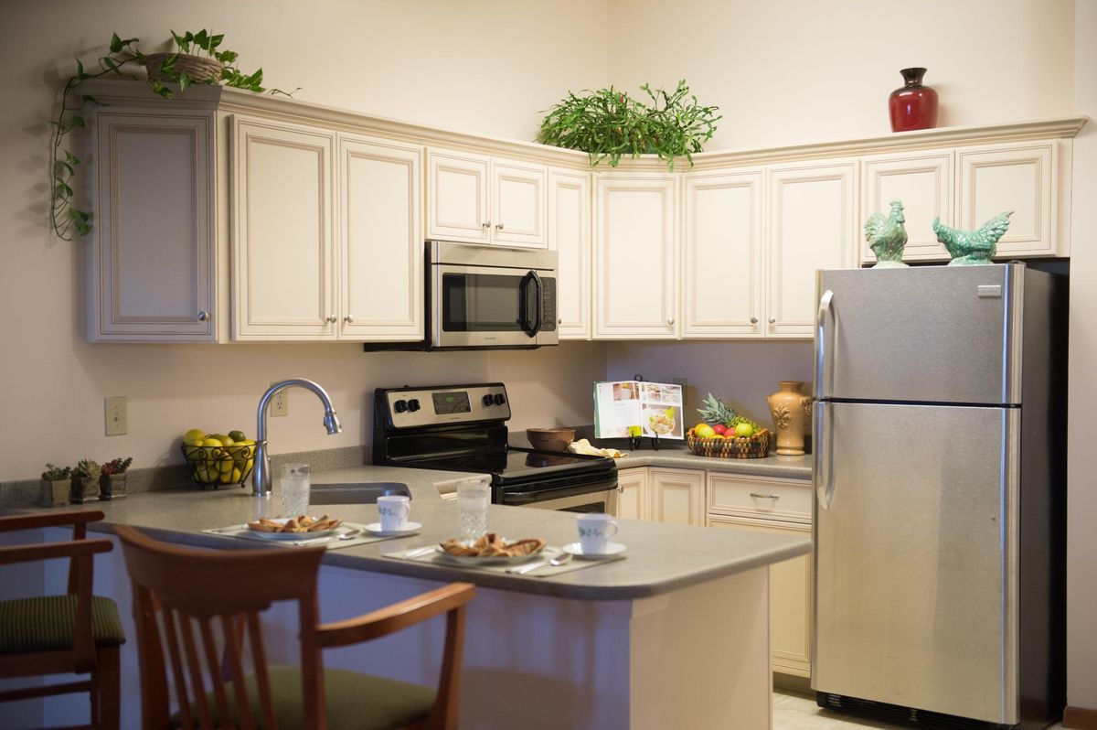 A modern kitchen with white cabinets and stainless steel appliances.
