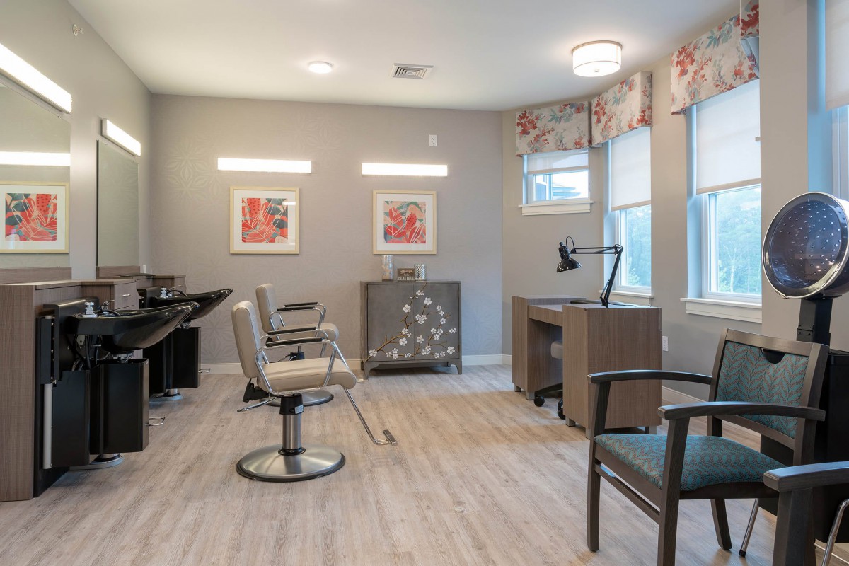 A modern hair salon interior with stylish chairs and large mirrors.