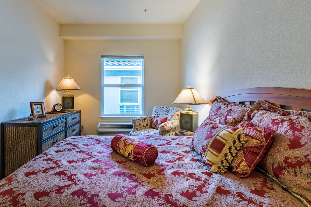 A cozy bedroom with colorful bedding and warm lighting from bedside lamps.