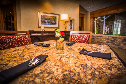 A beautifully set restaurant table with an elegant and cozy interior.