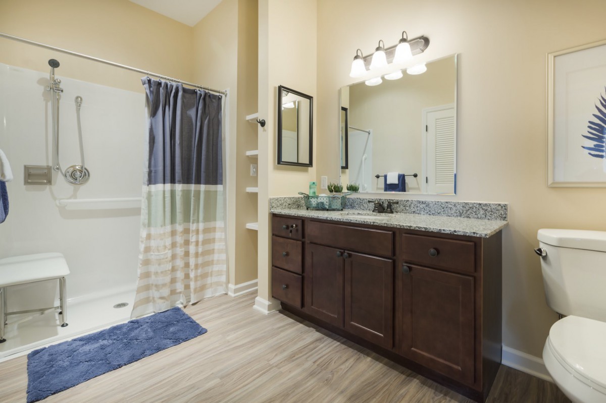 A modern bathroom featuring a double vanity and shower area.