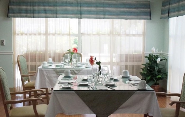 An elegantly set dining table in a restaurant with natural lighting.