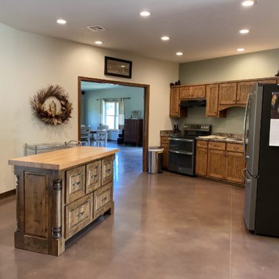 A modern kitchen featuring wood cabinets, a central island, stainless steel appliances, and an open floor plan.