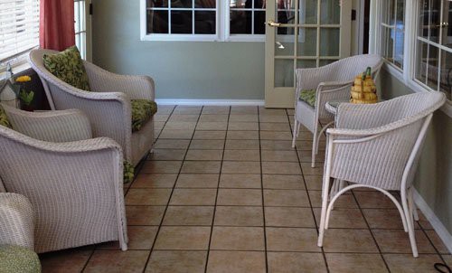 A cozy room with wicker furniture and tiled flooring.