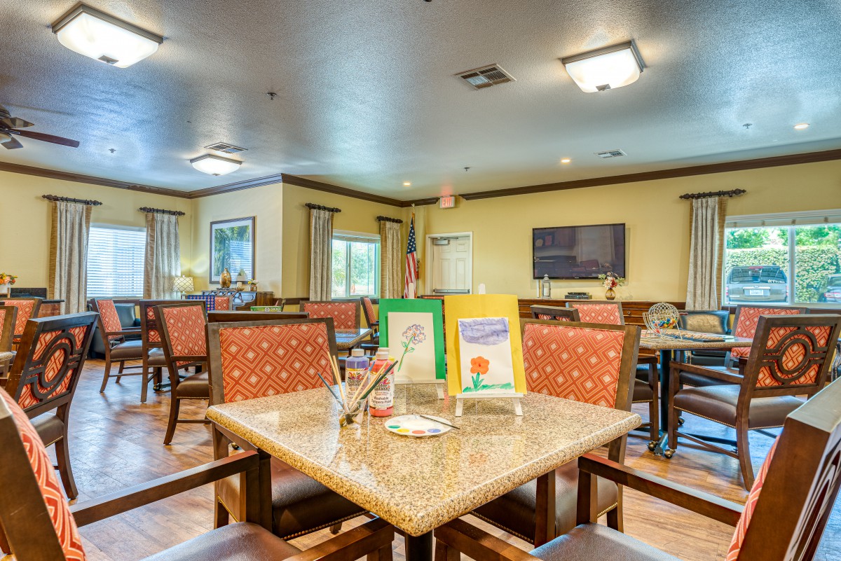 A spacious and well-lit dining area with neatly arranged tables and chairs, featuring colorful decor.
