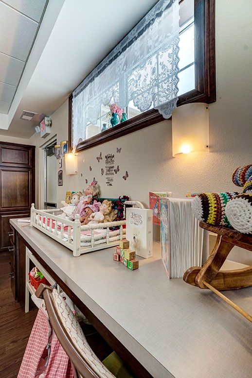 A cozy nursery with a changing table adorned with stuffed animals and colorful toys, complete with wall decorations.