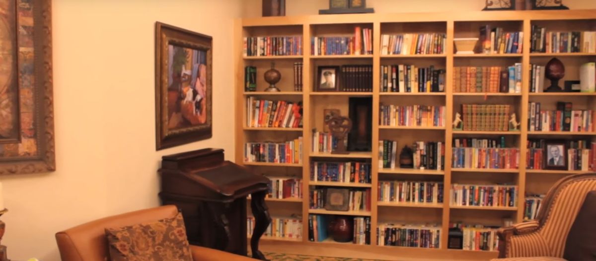 A cozy library corner with wooden bookshelves filled with various books.