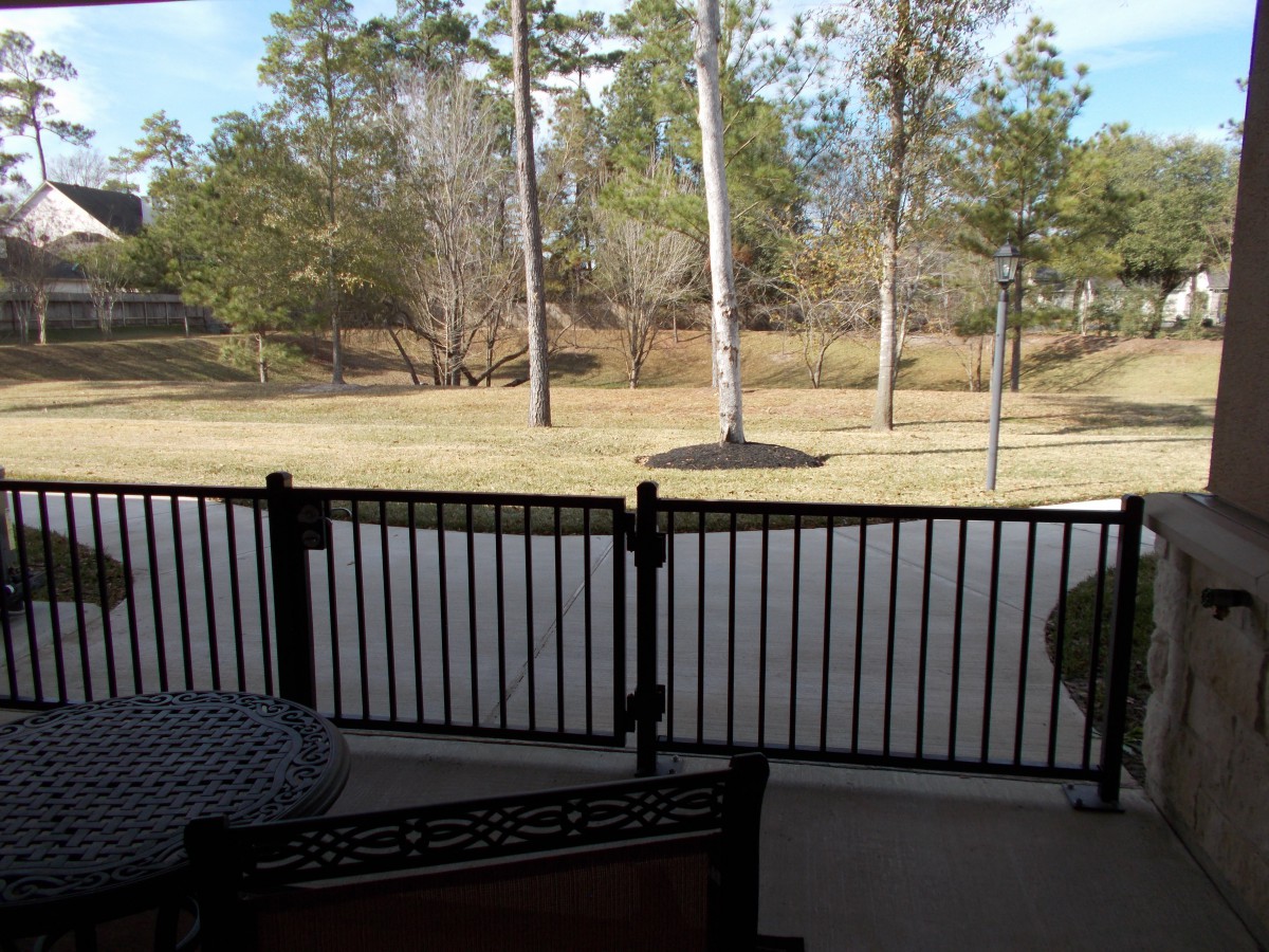 View of a backyard with a fence and trees.