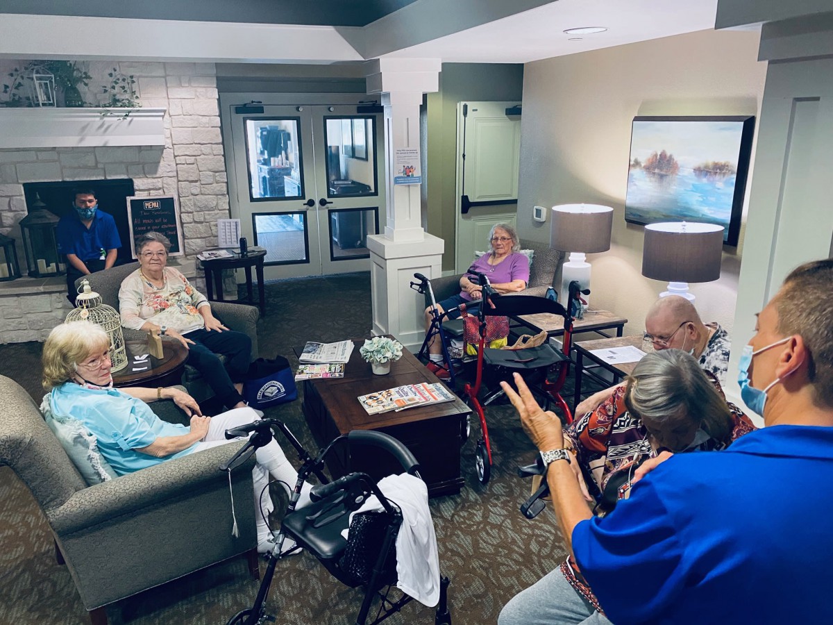 A group of seniors engaged in a lively discussion in a community lounge.