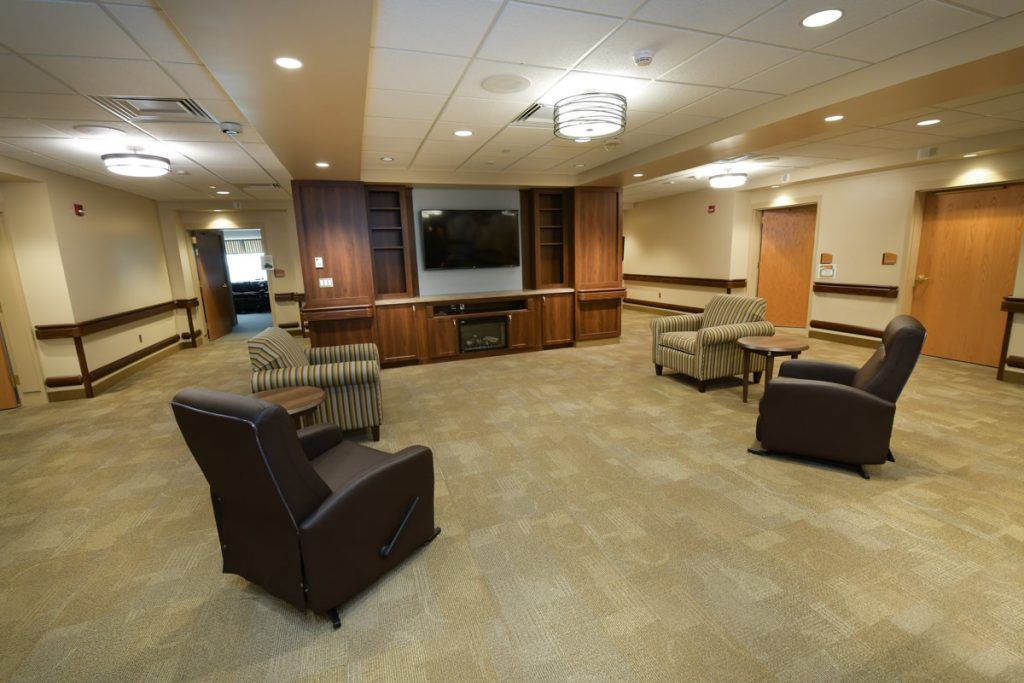 A modern lounge with comfortable seating and a large television.