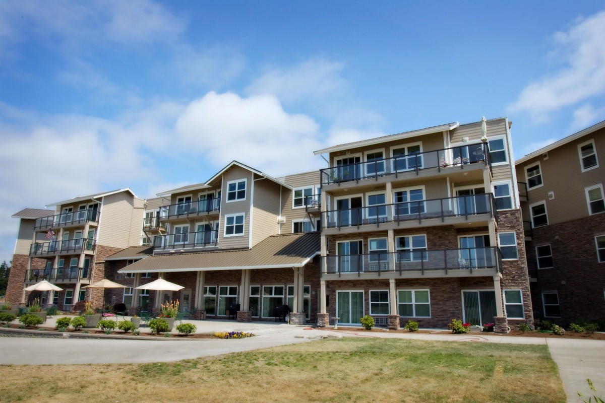 A modern residential building with balconies under a blue sky.