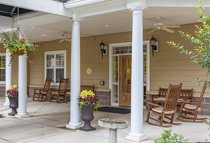 A welcoming porch with rocking chairs and flowers.