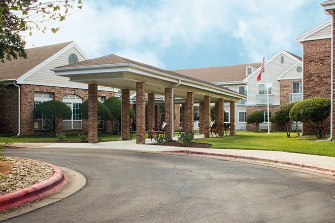A building entrance with a covered canopy and landscaped surroundings.