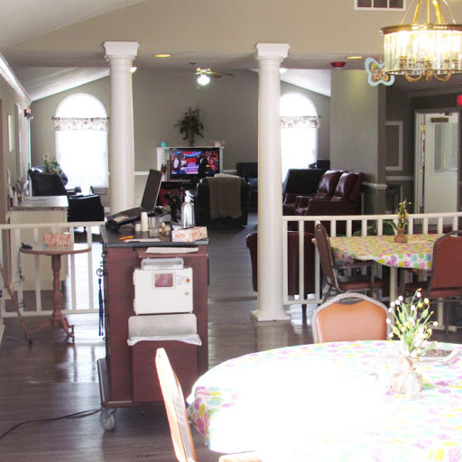 A spacious interior featuring a dining area with a table, chairs, and an open layout connecting to a reception space.