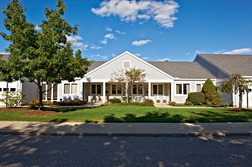 A charming residential home with a well-maintained front yard, set against a clear blue sky.