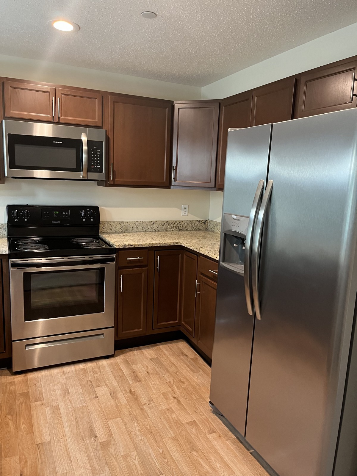 Modern kitchen with stainless steel appliances and wooden cabinets.