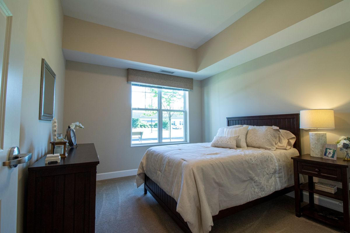 A simple and minimalist bedroom with a bed by the window.