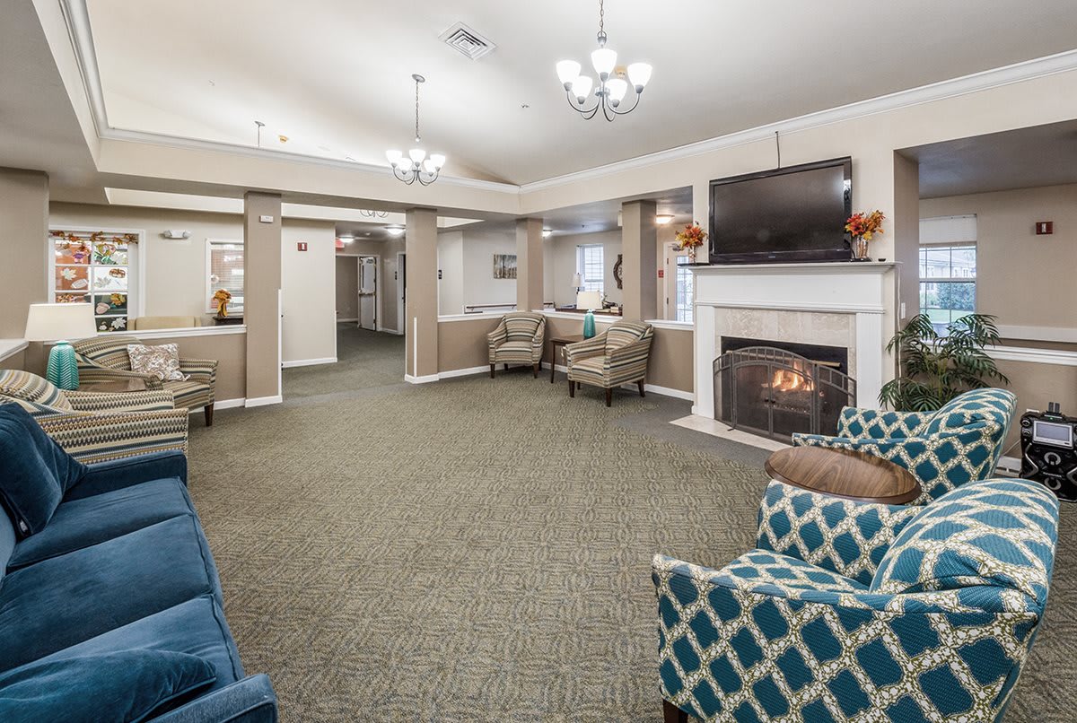 A cozy living room with a fireplace, seating area, and television.