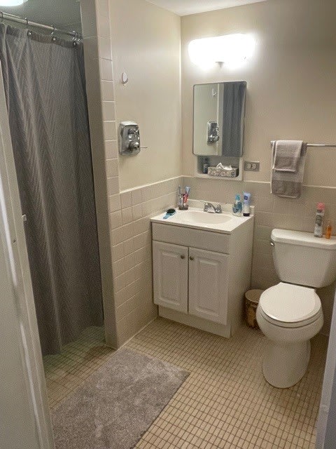 A clean and organized bathroom with a sink, mirror, toilet, and shower.