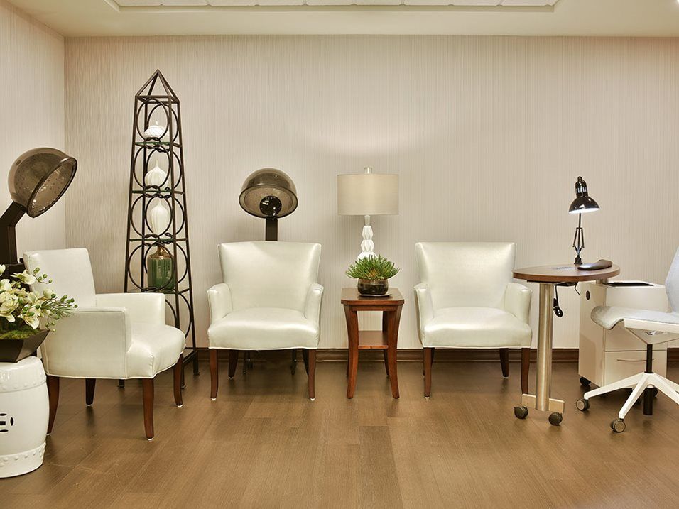 A modern waiting room with white chairs and stylish decor.