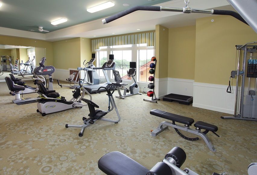 A well-equipped gym with various exercise machines and free weights.