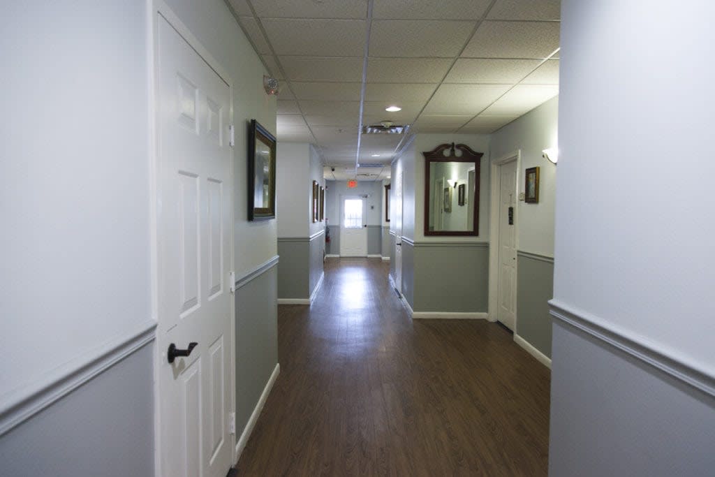 A quiet hallway with framed art on the walls and doors leading to rooms.