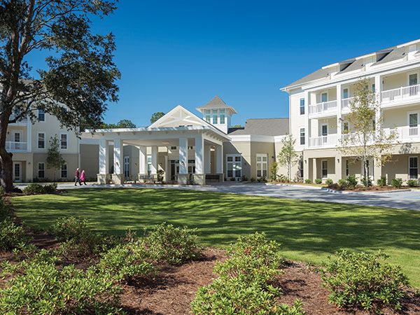 A residential building with a well-maintained landscape under a clear blue sky.