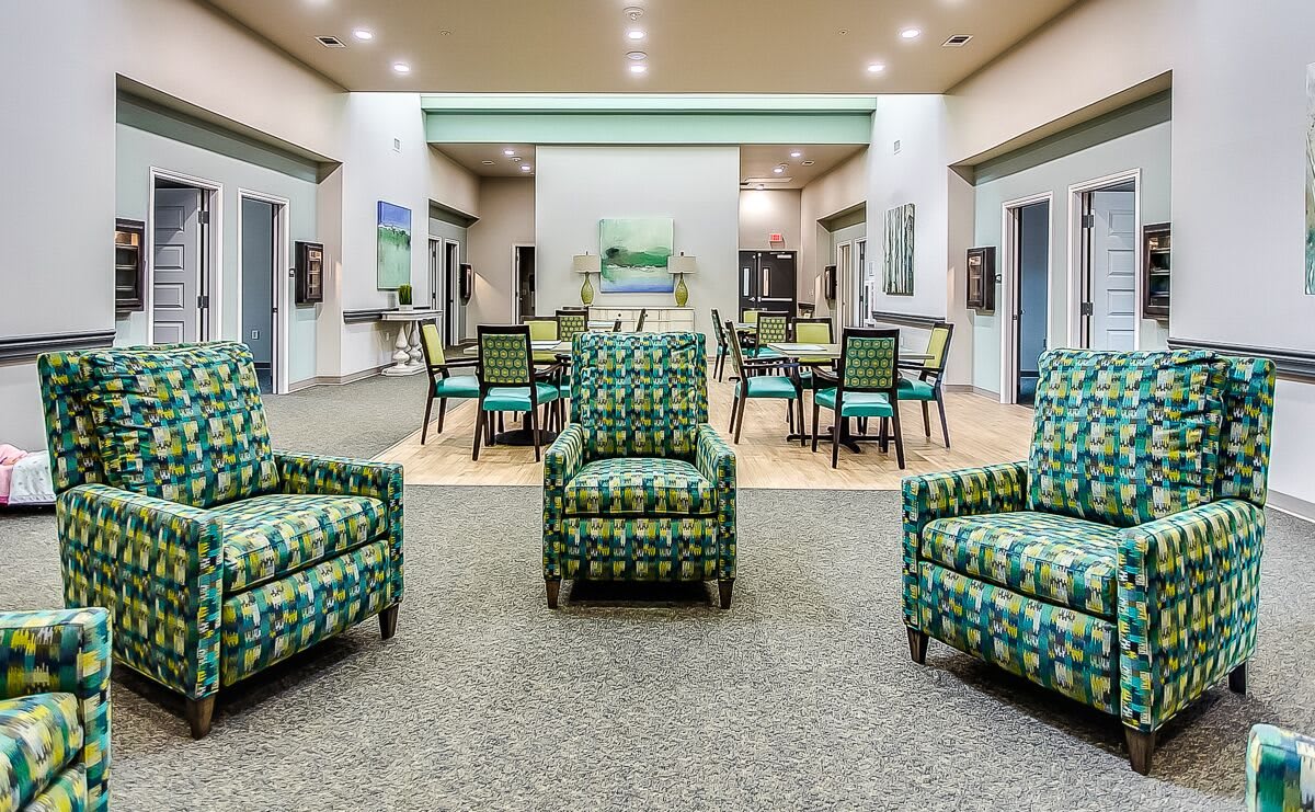 A modern lobby with colorful chairs and tables arranged in a welcoming seating area.